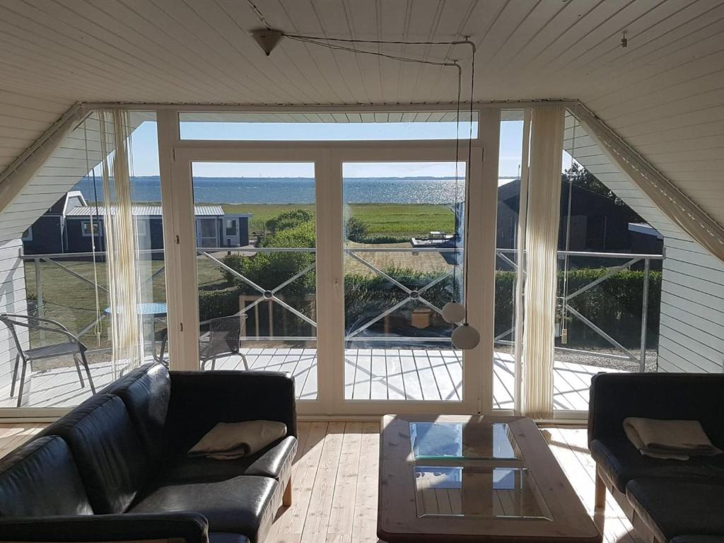 a living room with a couch and a large window at Holiday Home Dunja - 200m to the inlet in The Liim Fiord by Interhome in Vinderup