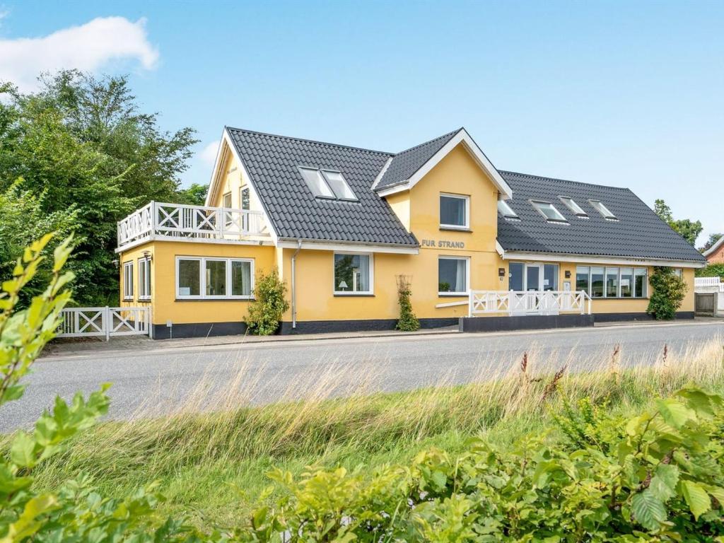 a yellow house on the side of a road at Holiday Home Rina - 30m to the inlet in The Liim Fiord by Interhome in Fur
