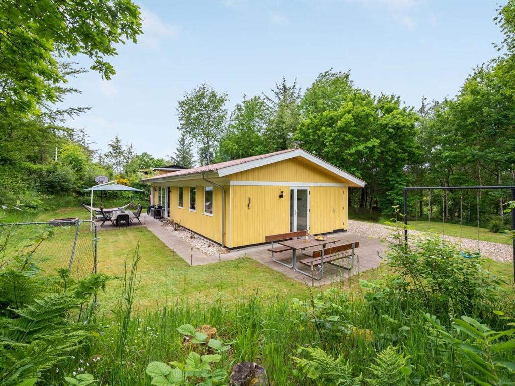 a yellow tiny house in the middle of a yard at Holiday Home Ethil - 300m to the inlet in The Liim Fiord by Interhome in Lihme