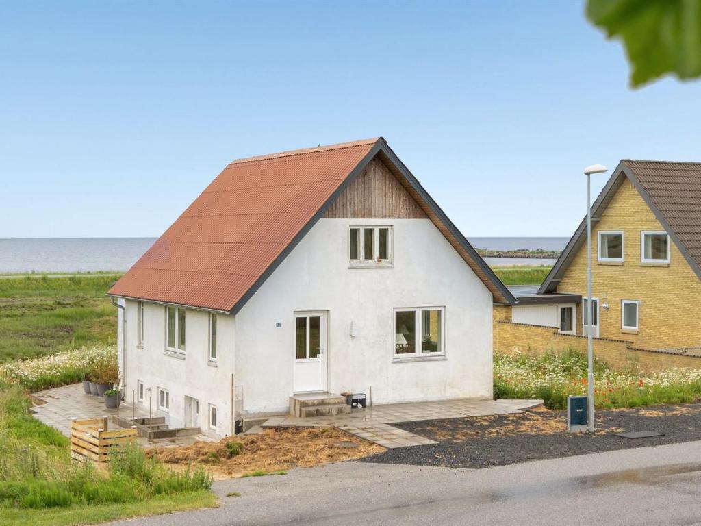 een wit huis met een bruin dak bij Holiday Home Thomsen - 200m to the inlet in The Liim Fiord by Interhome 