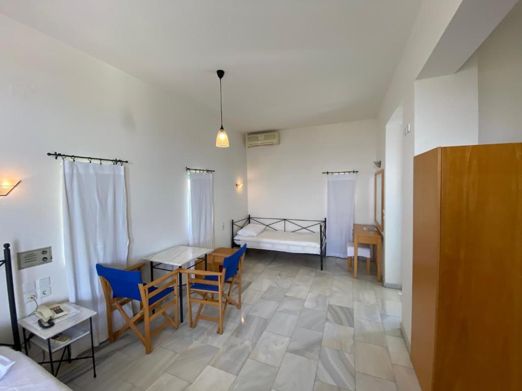 a room with a bed and a table and chairs at Hotel Plakures in Falasarna