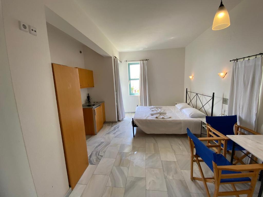 a room with a bed and a table and chairs at Hotel Plakures in Falasarna