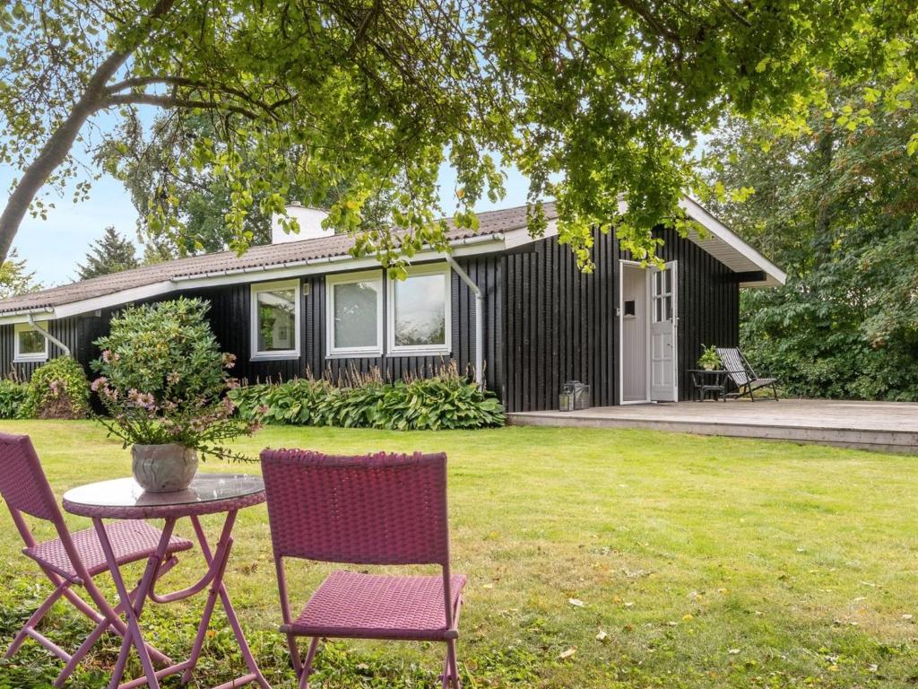 a table and chairs in front of a house at Holiday Home Suoma - 400m to the inlet in The Liim Fiord by Interhome in Roslev