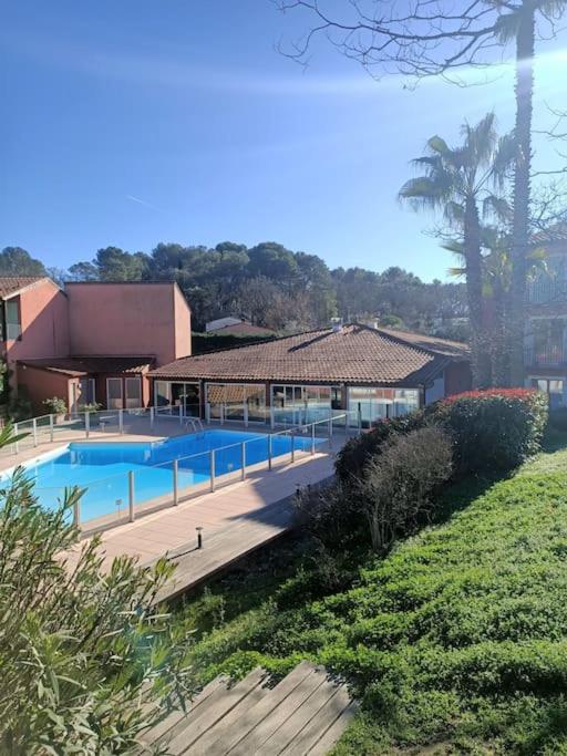 uma casa com piscina em frente a uma casa em Magnifique studio avec piscine em Mouans-Sartoux