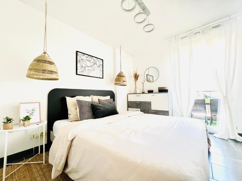 a white bedroom with a large bed and white walls at Les Jardins des Senteurs - Appartement privé avec piscine et parking in Grasse