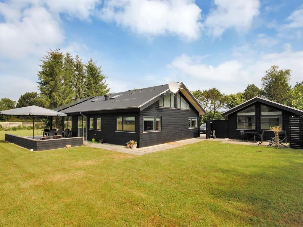 una casa modular negra con un gran patio en Holiday Home Etly - 600m to the inlet in The Liim Fiord by Interhome, en Roslev