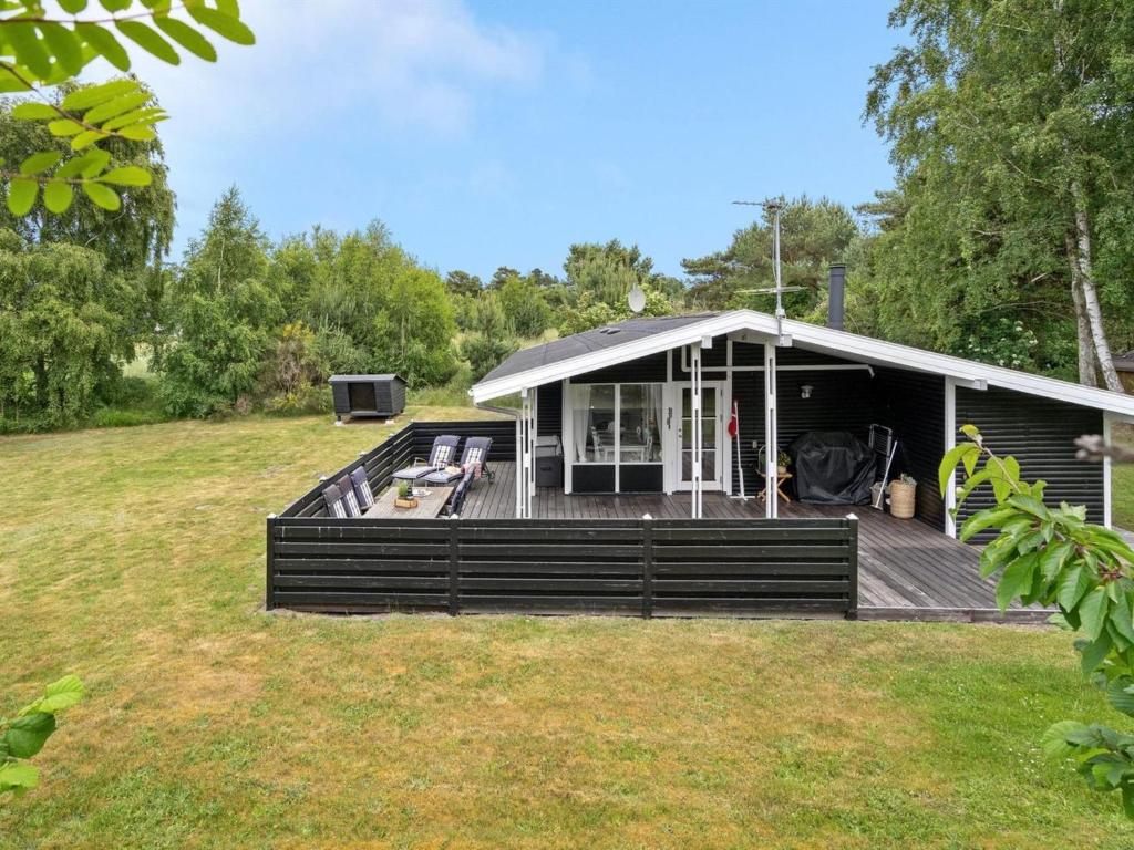 a large house with a deck and a yard at Holiday Home Morten - 500m from the sea in Djursland and Mols by Interhome in Ebeltoft