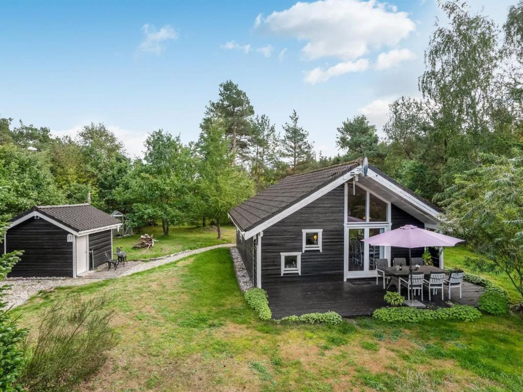 a log cabin with a porch and a patio at Holiday Home Fiallar - 7-5km from the sea in Djursland and Mols by Interhome in Rønde