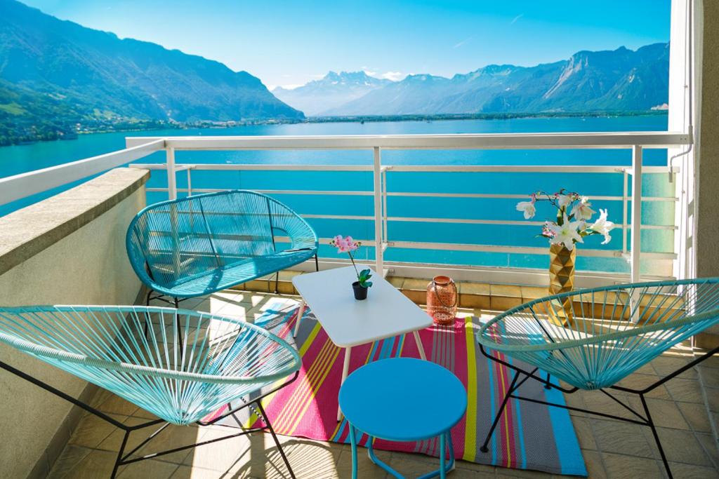 d'un balcon avec deux chaises et une table sur un bateau. dans l'établissement Lake View - Appt Central 2 Bedroom, 1 Bath, à Montreux