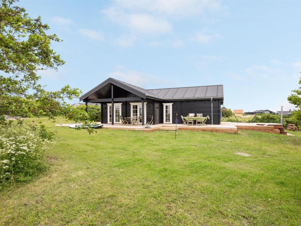 ein schwarzes Haus mit einem großen Hof in der Unterkunft Holiday Home Siebelt - 200m from the sea in Djursland and Mols by Interhome in Knebel