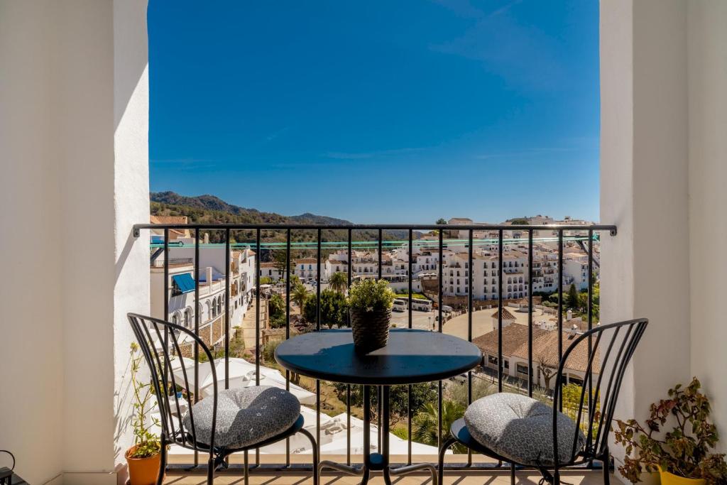 a table and chairs on a balcony with a view at Apartamento Essence by Solset in Frigiliana