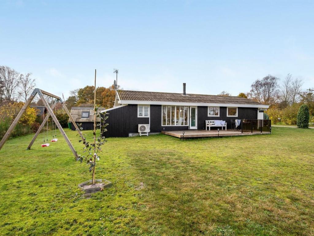 ein Haus mit einem Hof mit Schaukel in der Unterkunft Holiday Home Joon - 300m from the sea in Djursland and Mols by Interhome in Ørsted