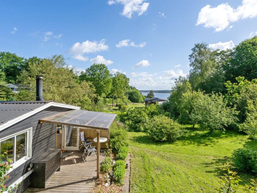 a cottage with a deck and a view of the water at Holiday Home Self - 400m to the inlet in The Liim Fiord by Interhome in Løgstrup
