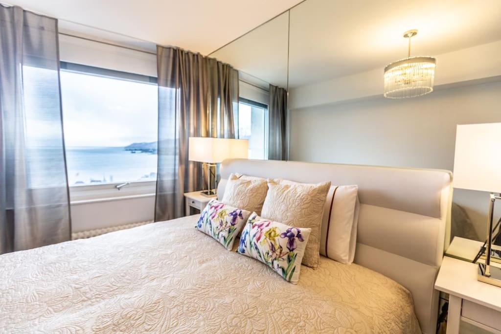 a bedroom with a bed with a large window at Perfect apartment Montreux centre - Lake View in Montreux