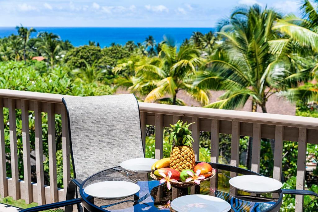 una mesa con un bol de fruta en el balcón en Keauhou Resort 113, en Kailua-Kona