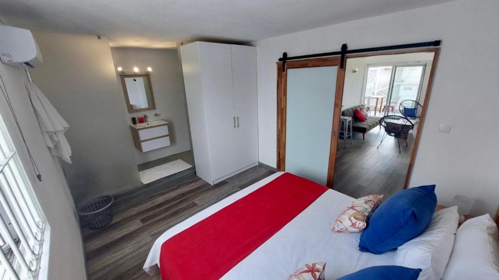 1 dormitorio con 1 cama grande con manta roja en Serenity apartments, en Trou aux Biches