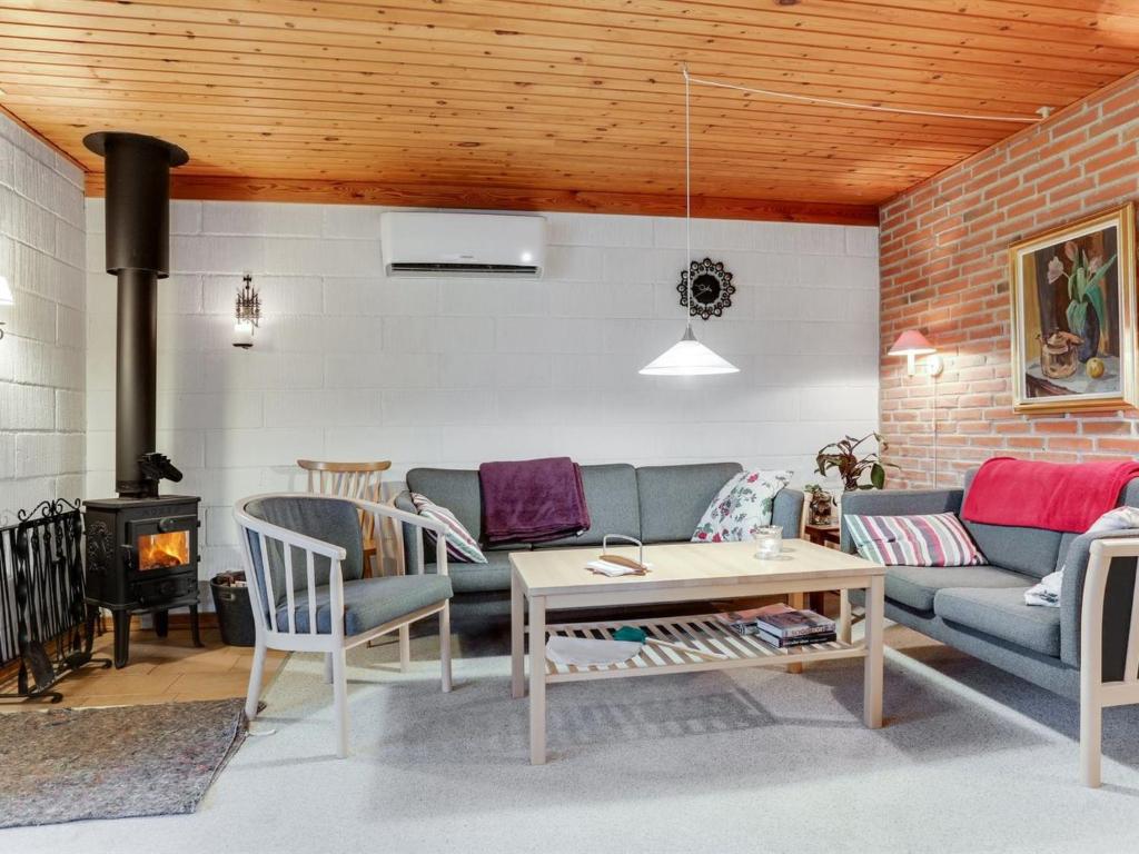 uma sala de estar com um sofá, uma mesa e um fogão em Holiday Home Anemarie - 450m from the sea in NE Jutland by Interhome em Sæby