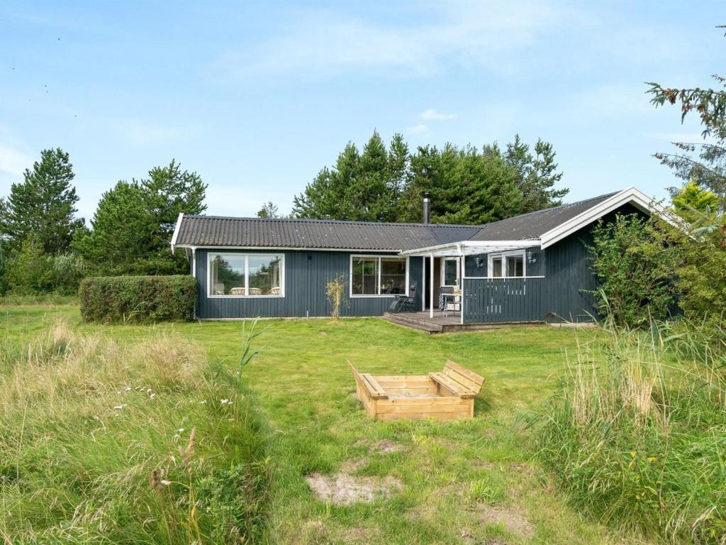 een blauw huis in een veld met een tuin bij Holiday Home Glum - 300m from the sea in NE Jutland by Interhome in Sæby