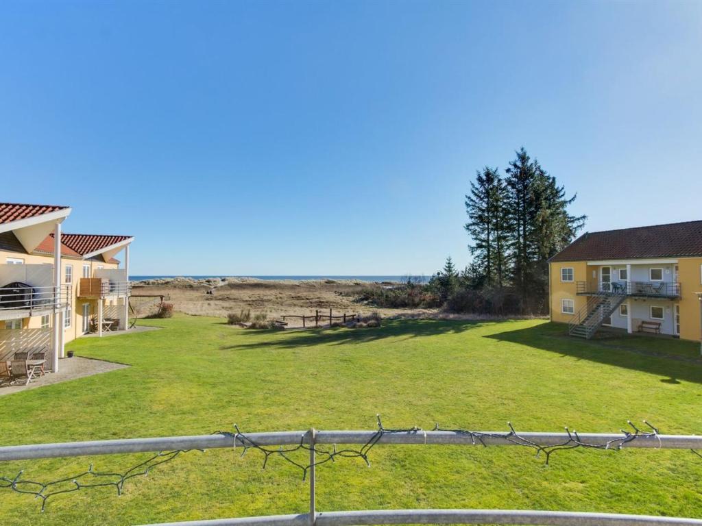 vistas a un patio con una casa y una valla en Apartment Dafna - 100m from the sea in NE Jutland by Interhome, en Hals