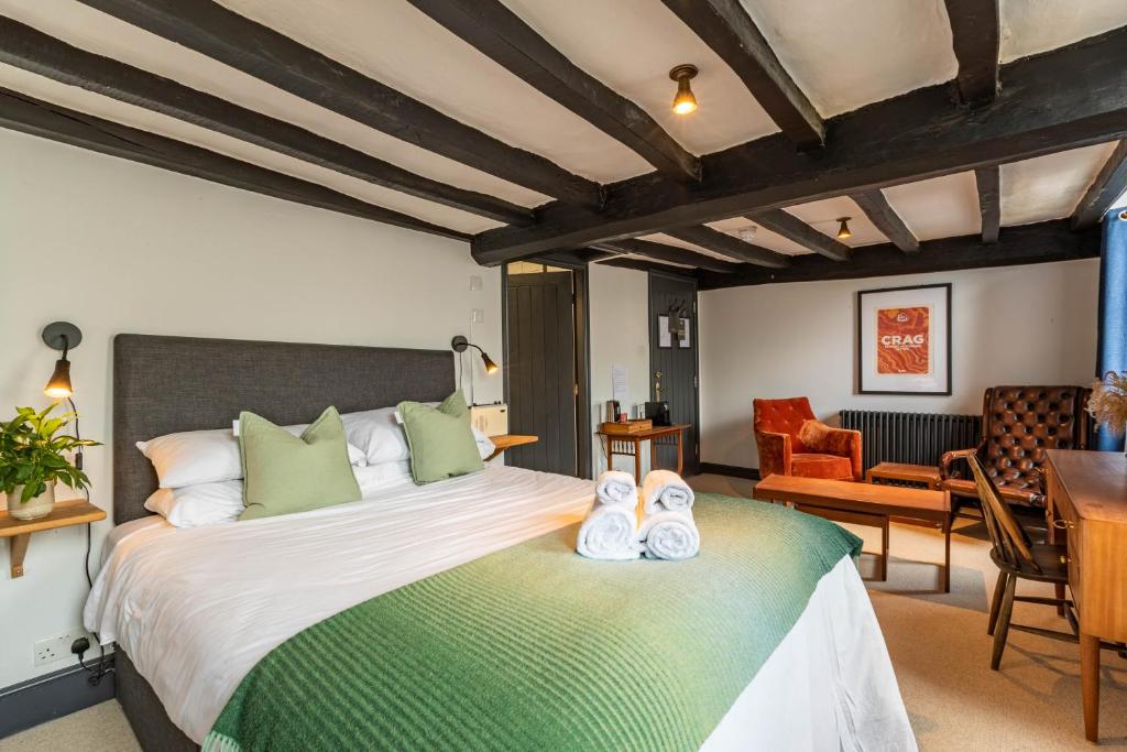 a bedroom with a large bed with shoes on it at Royal Oak Pub in Cartmel
