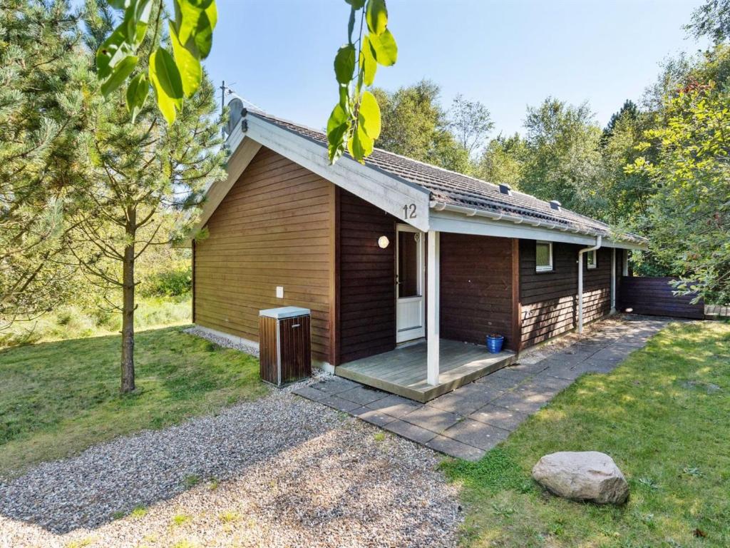 a log cabin with a porch and a yard at Holiday Home Jussi - 3-5km from the sea in NW Jutland by Interhome in Brovst
