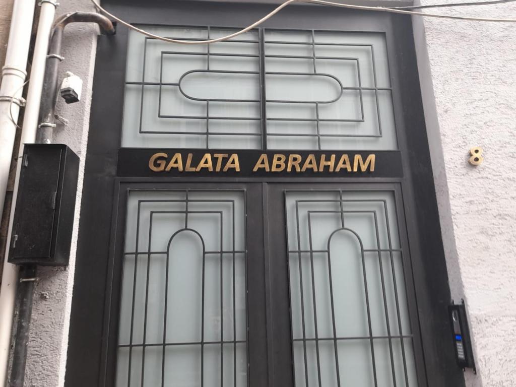 uma porta para um edifício com um sinal em Galata Abraham by NewInn em Istambul