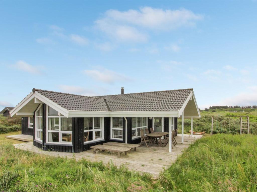 ein Haus mit einer Veranda und einem Picknicktisch in der Unterkunft Holiday Home Fanija - 200m from the sea in NW Jutland by Interhome in Hjørring