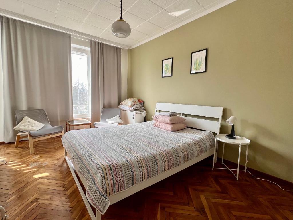 a bedroom with a bed and a chair and a window at La Gare Apartment in Varna City