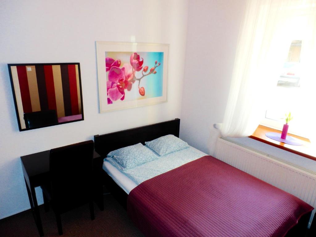 niewielka sypialnia z łóżkiem i oknem w obiekcie Hostel Coco w Warszawie