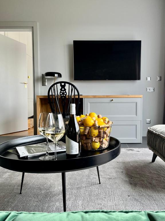 a table with a basket of fruit and a bottle of wine at Apartament Hawkinsa in Jelenia Góra