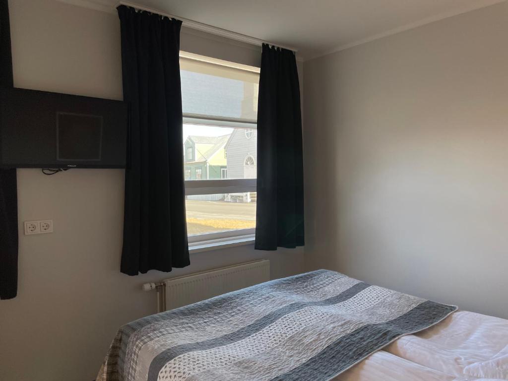 Rúm í herbergi á Akkeri Guesthouse