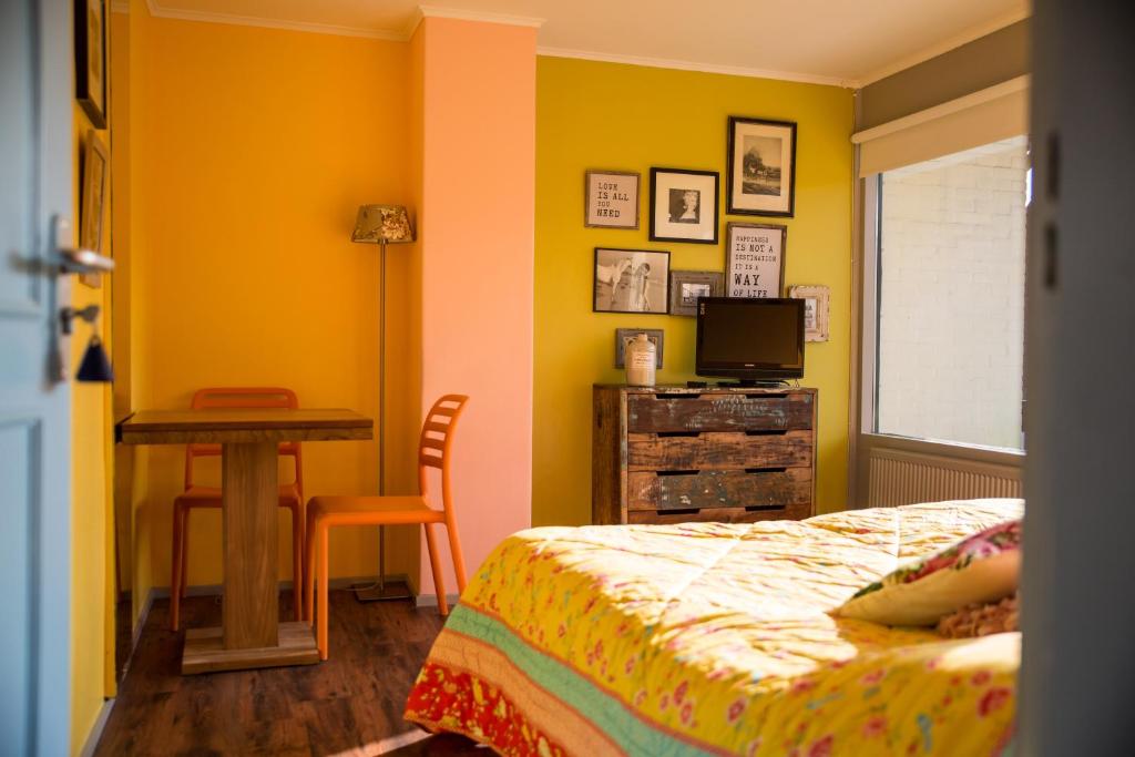 Schlafzimmer mit einem Bett, einem Tisch und einem Schreibtisch in der Unterkunft Hotel Domburg4you in Domburg