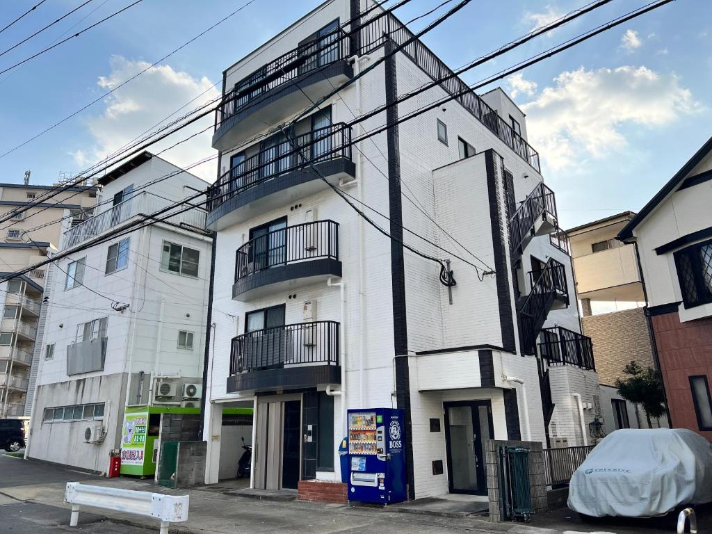 un edificio blanco con balcones en un lateral en Fieldnever Apartment STAY - Maisonette Family room en Fukuoka