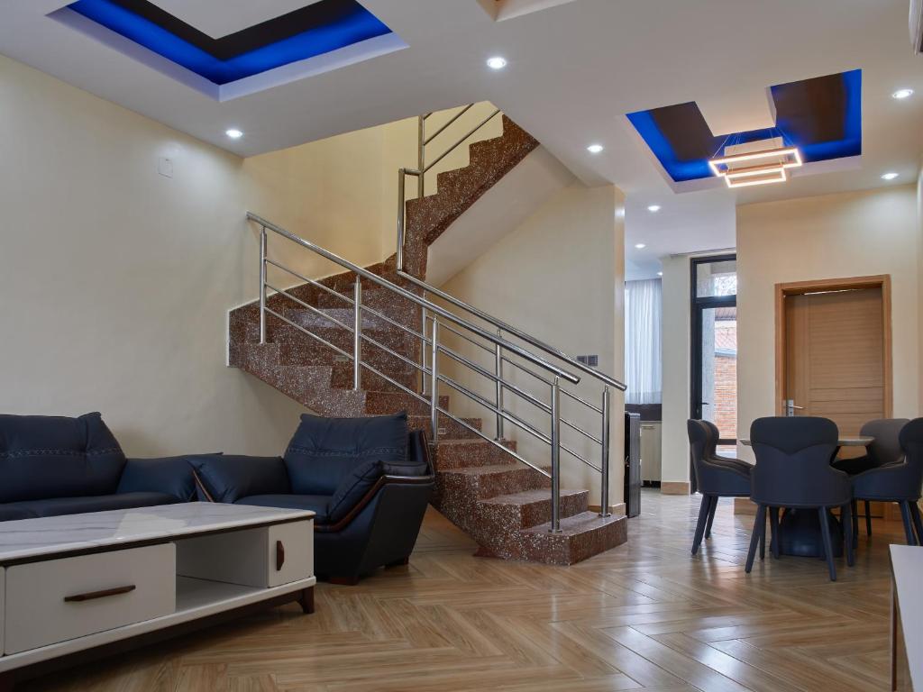 una sala de estar con una escalera con techos azules en Unique Apartment en Kigali