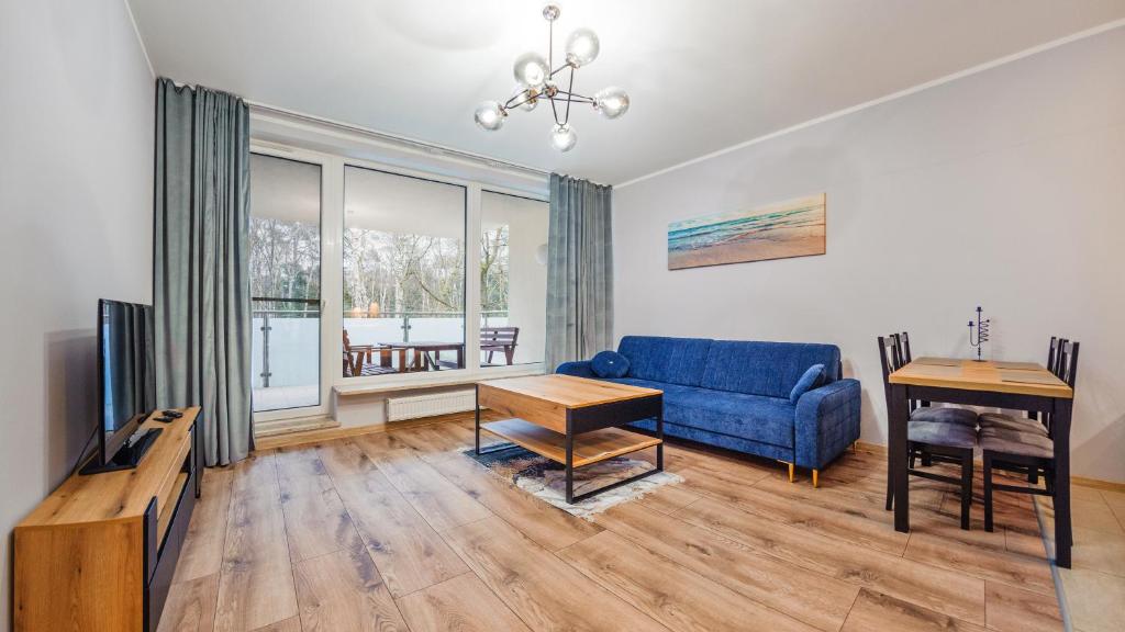 sala de estar con sofá azul y mesa en Apartamenty Sun & Snow Międzyzdroje Aquamarina, en Międzyzdroje