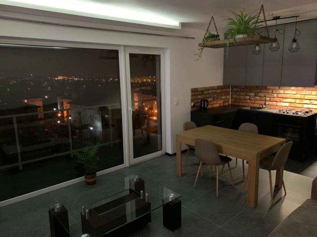 kuchnia i jadalnia ze stołem i dużym oknem w obiekcie Apartament Corner Śrem w mieście Śrem