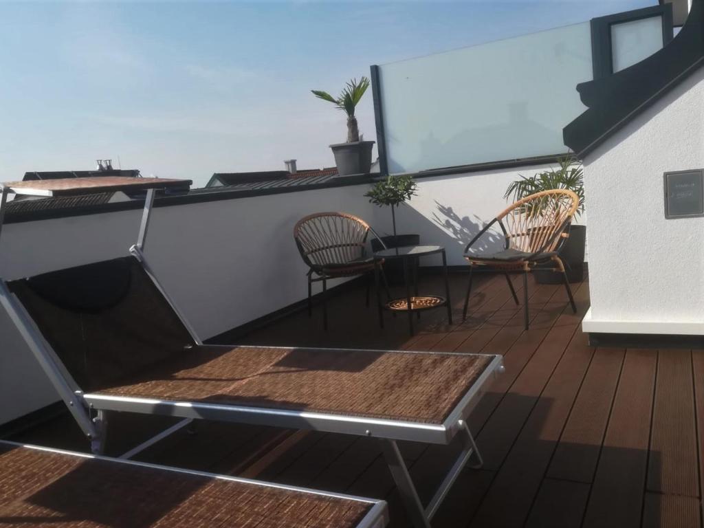 einen Balkon mit 2 Stühlen und einem Tisch in der Unterkunft PENTHOUSE Griemann 2 für max 4 Personen mit eigener großer Dachterrasse zum Relaxen! in Illmitz