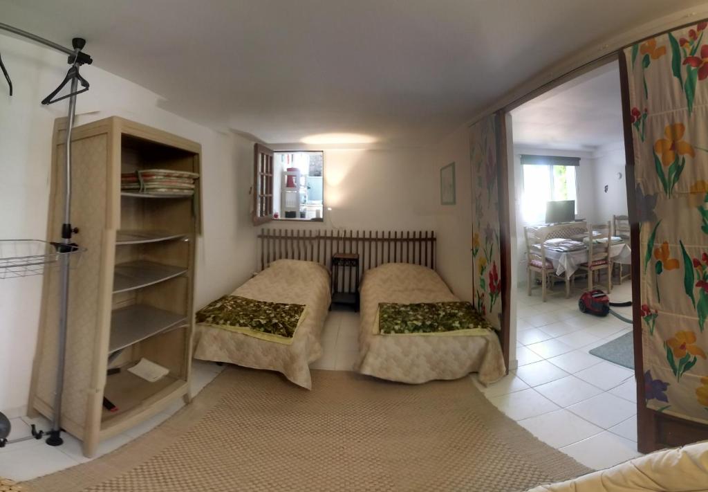 a living room with two beds and a table at Les Nympheas, appart, grand jardin au calme, parking gratuit,15 min Disneyland, in Crécy-la-Chapelle