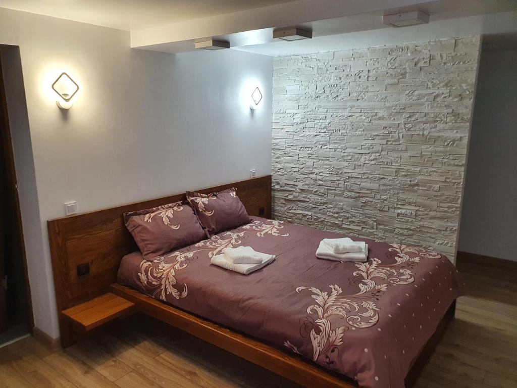 een slaapkamer met een bed met twee handdoeken erop bij Rooms Poienita in Slănic-Moldova