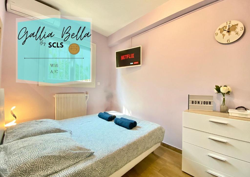 une chambre avec un lit et une horloge au mur dans l'établissement Gallia Bella By SCLS Locations, à Cannes