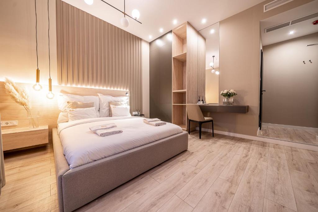 a bedroom with a large bed and a desk at Karoly Boutique Suites, Best Location by BQA in Budapest