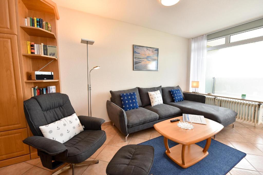 a living room with a couch and a table and chairs at Haus "Panorama" Appartement PAN097 in Duhnen