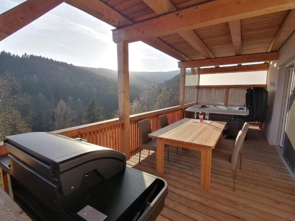eine abgeschirmte Veranda mit einem Grill und einem Tisch in der Unterkunft Ferienhaus Schilcherland in Hochneuberg