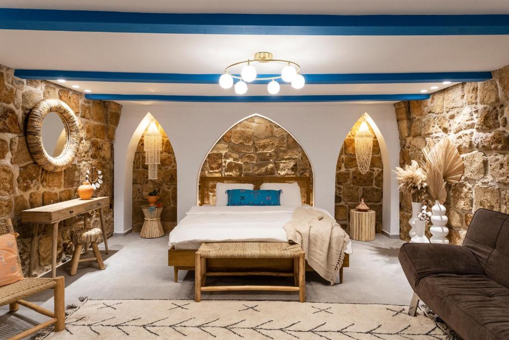 um quarto com uma cama e um sofá em Santorini em Acre