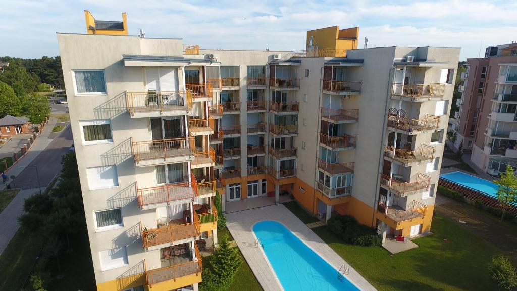 an apartment building with a swimming pool next to it at Viktória Beach Apartman Gold 2. Siófok in Siófok