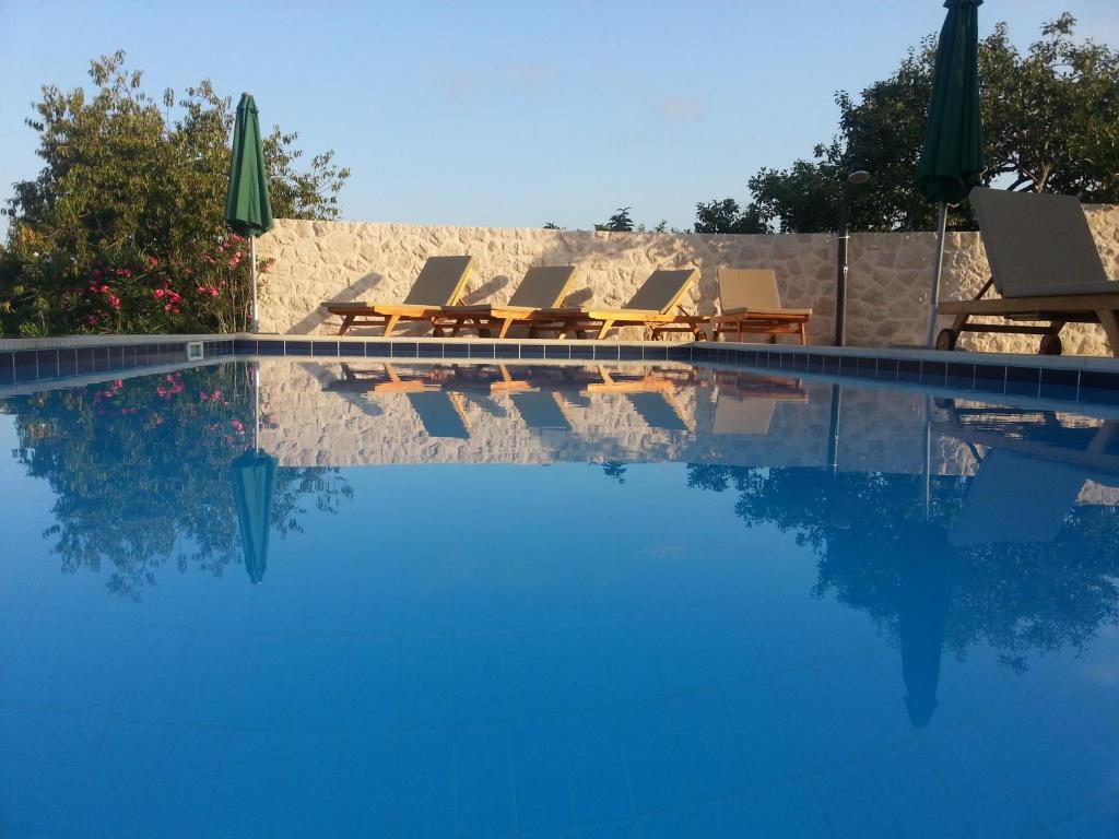 een groep ligstoelen en een zwembad bij Villa Antonija heated private pool, near Dubrovnik,8plus 2 p ideal for families and groups in Čilipi