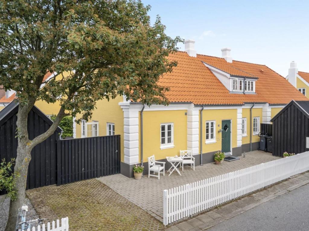 a yellow and white house with a white fence at Holiday Home Stephie - 1-1km from the sea in NW Jutland by Interhome in Skagen