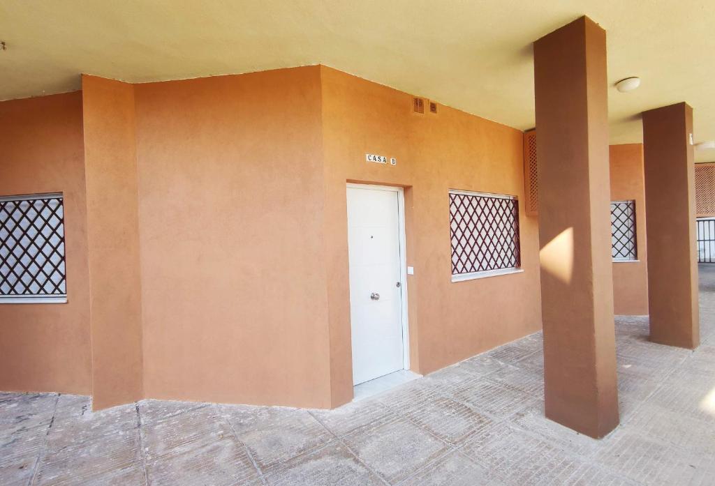 Habitación vacía con puerta blanca y paredes de color naranja en APARTAMENTOS SANLUCAR CASA B, en Sanlúcar de Barrameda