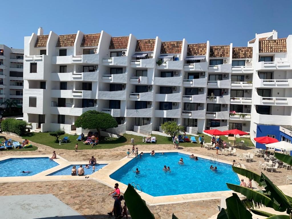 un grand immeuble avec une grande piscine dans l'établissement Apartamentos Eurhostal 3000, à Alcossebre