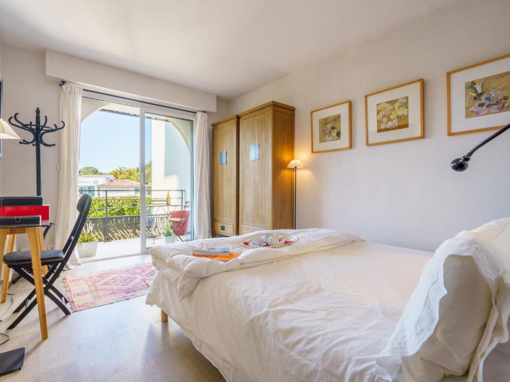 1 dormitorio con cama, escritorio y balcón en Apartment Golf de Chiberta by Interhome en Anglet